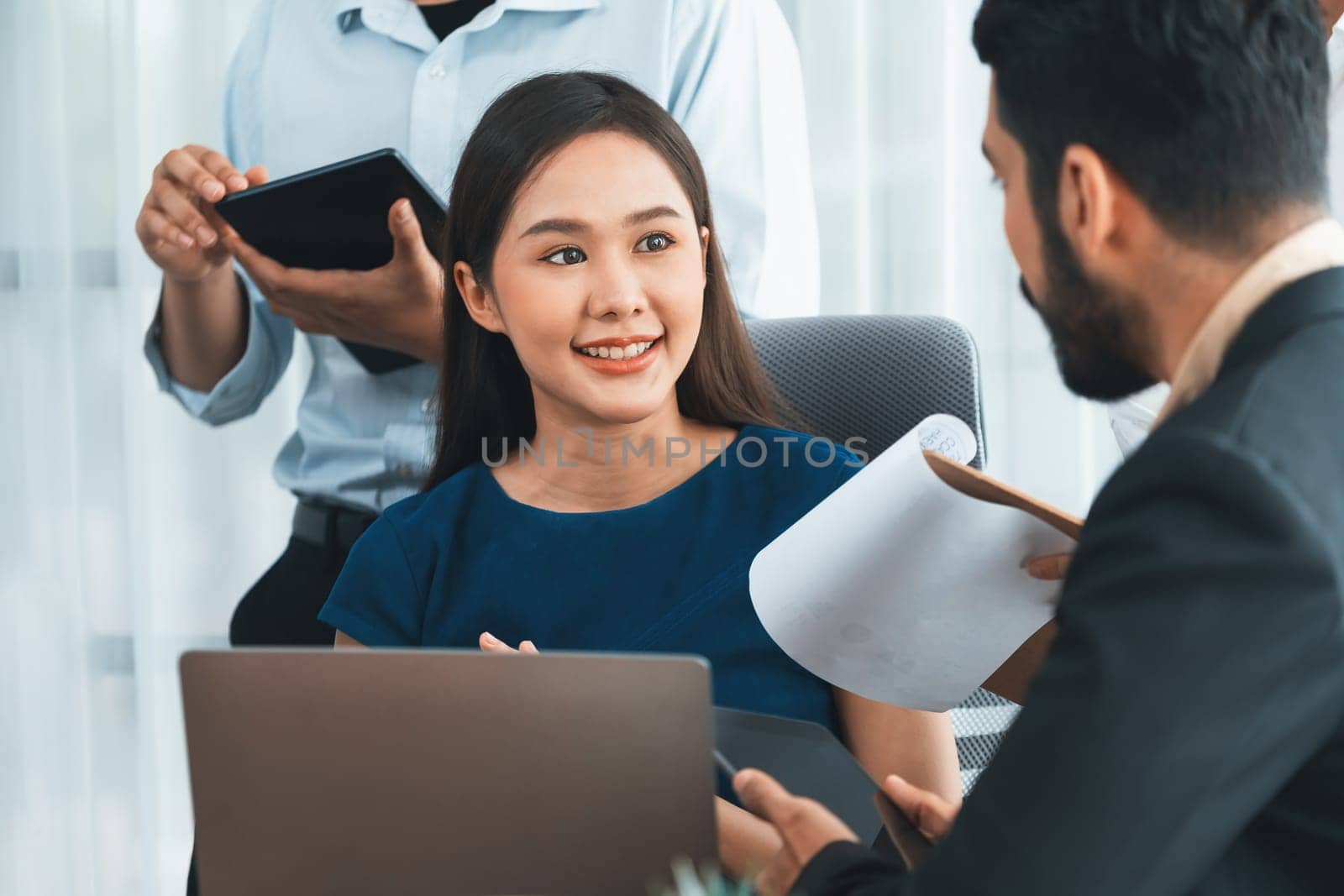 Professional Asian employee work together as team in corporate office, discussing business plans and data to achieve success on desk with laptop. Modern office worker teamwork concept. Concord