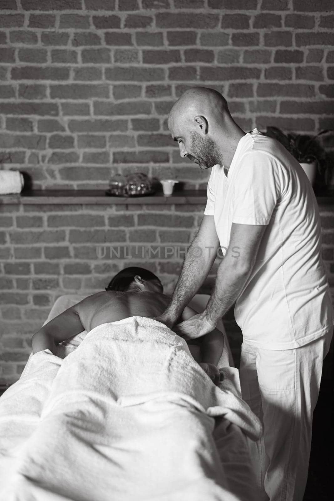 hispanic adult fit woman enjoy massage by physiotherapist in the therapeutical bed by verbano