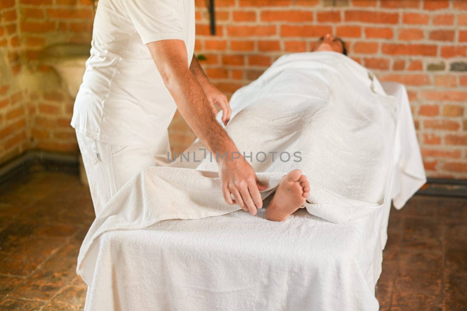 hispanic brunette adult fit woman ready for being massage by physiotherapist in the therapeutical bed