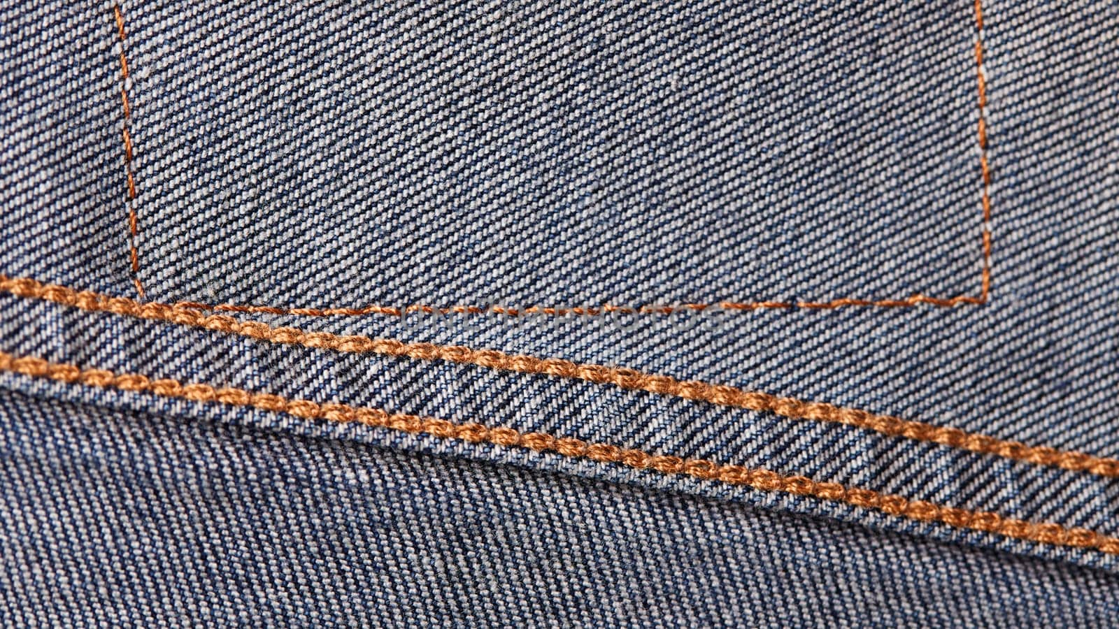 Seams on jeans close-up in high-resolution. Stitching on denim on the inside. Fabric texture. Blue jeans background and texture. Denim texture on the underside of the textile.