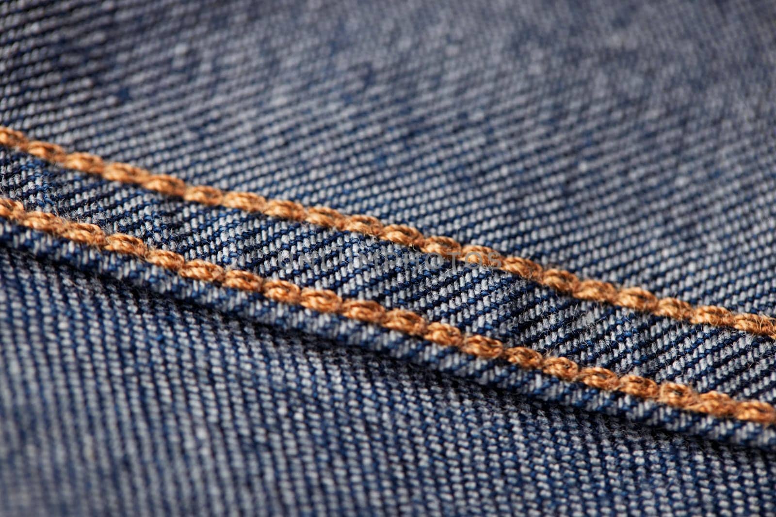 Seams on jeans close-up in high-resolution. Stitching on denim on the inside. Fabric texture. Blue jeans background and texture. Denim texture on the underside of the textile.