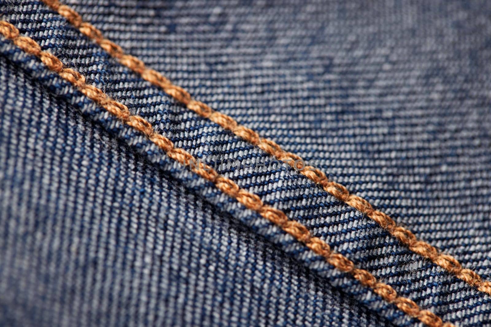 Seams on jeans close-up in high-resolution. Stitching on denim on the inside. Fabric texture. Blue jeans background and texture. Denim texture on the underside of the textile.