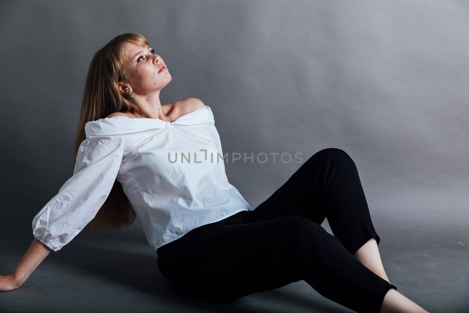 fashionable woman in dark pants posing on the floor by Simakov