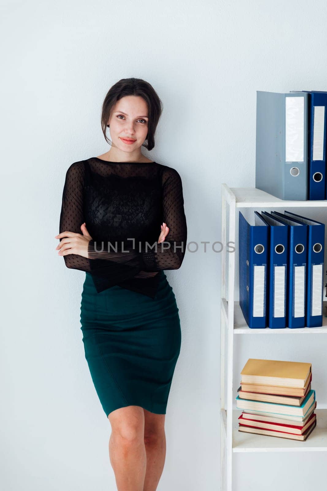 business woman stands at a shelf with folders in the office
