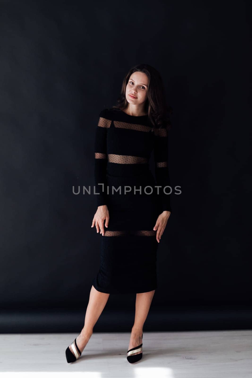 brunette in a dark dress poses on a dark background by Simakov