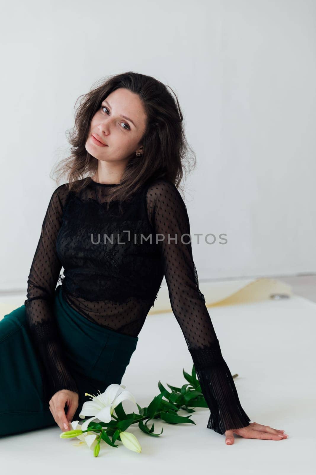 beautiful woman sitting on the floor near flowers by Simakov