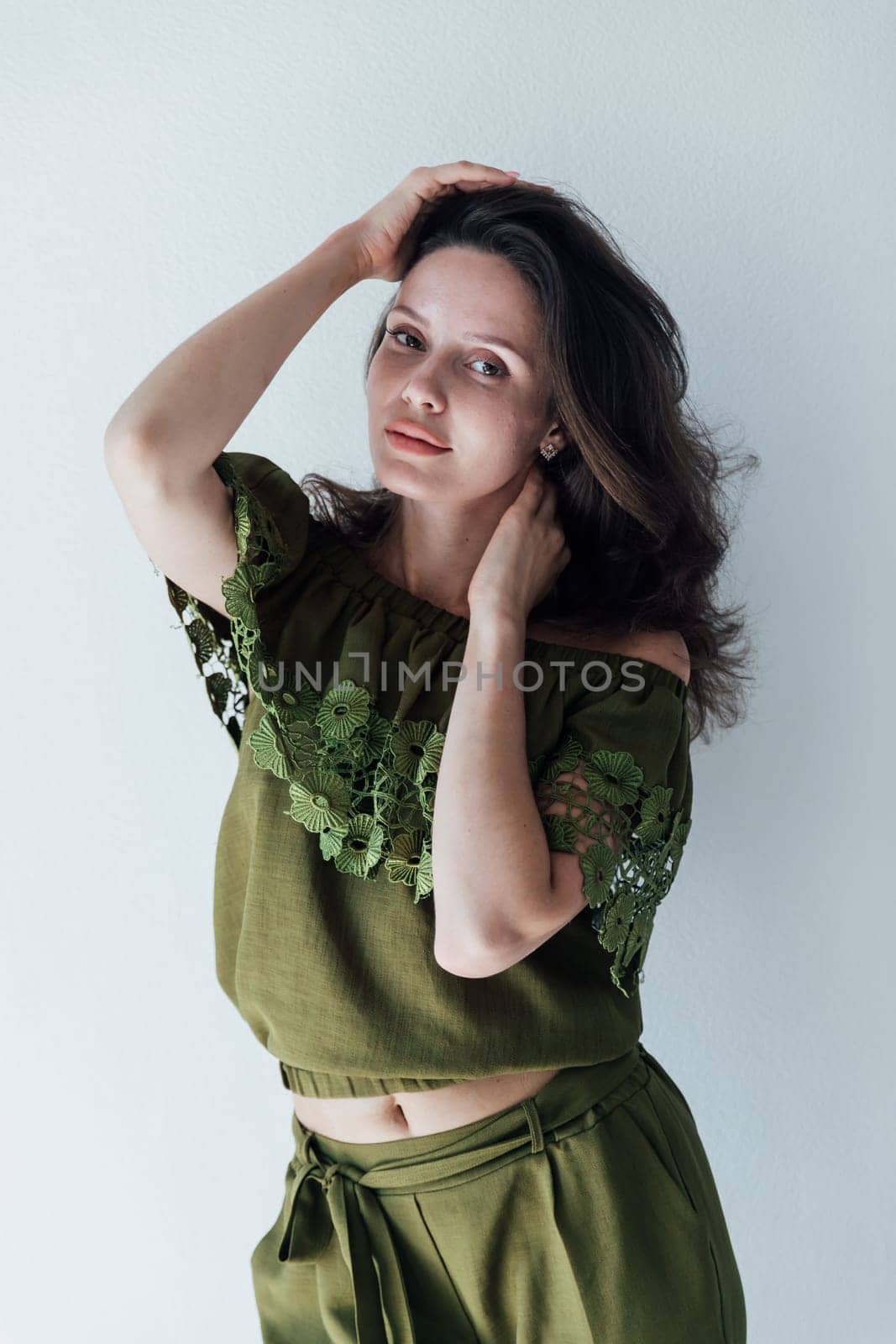 brunette stands on white background posing in the room