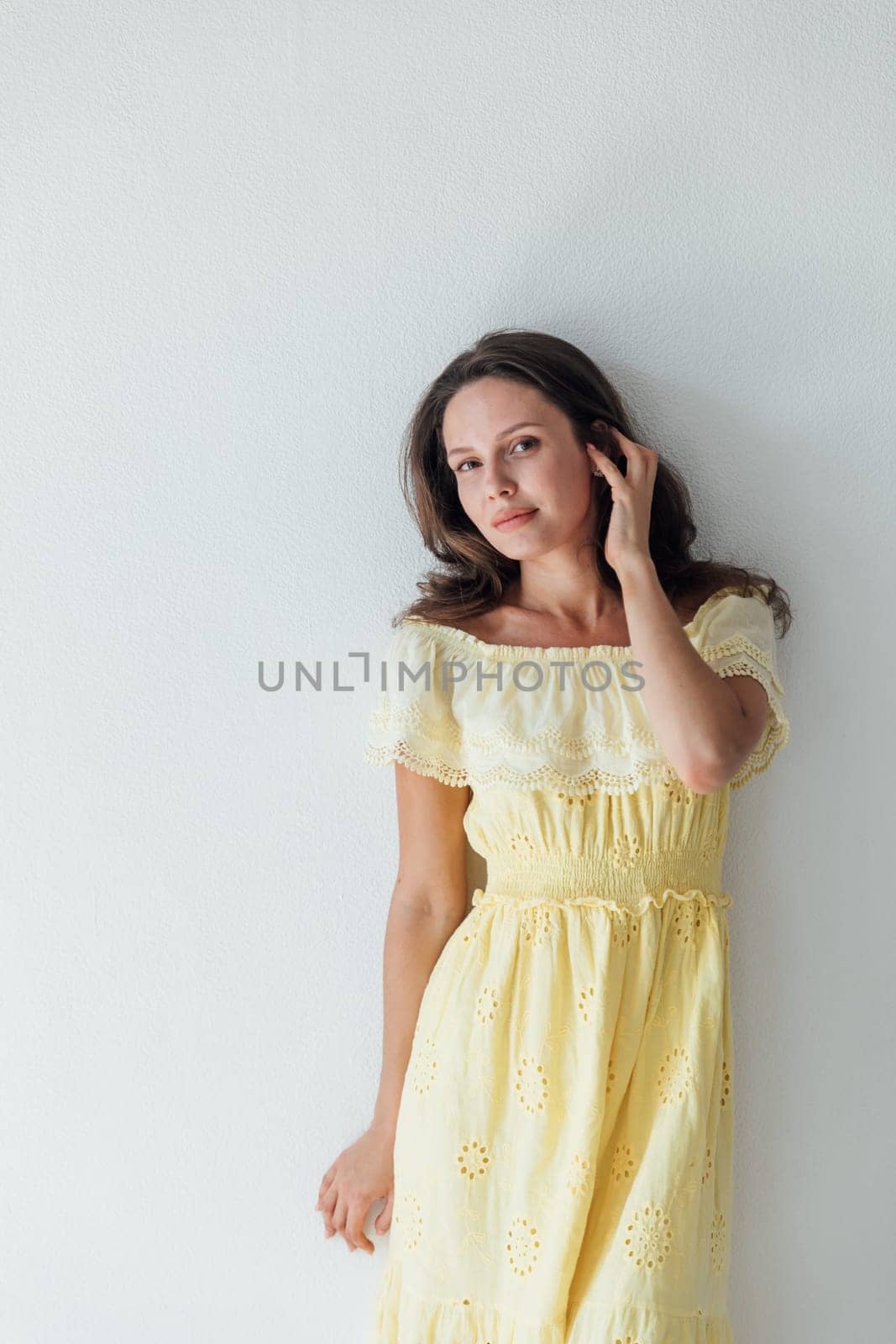 woman in a yellow dress on a white background poses