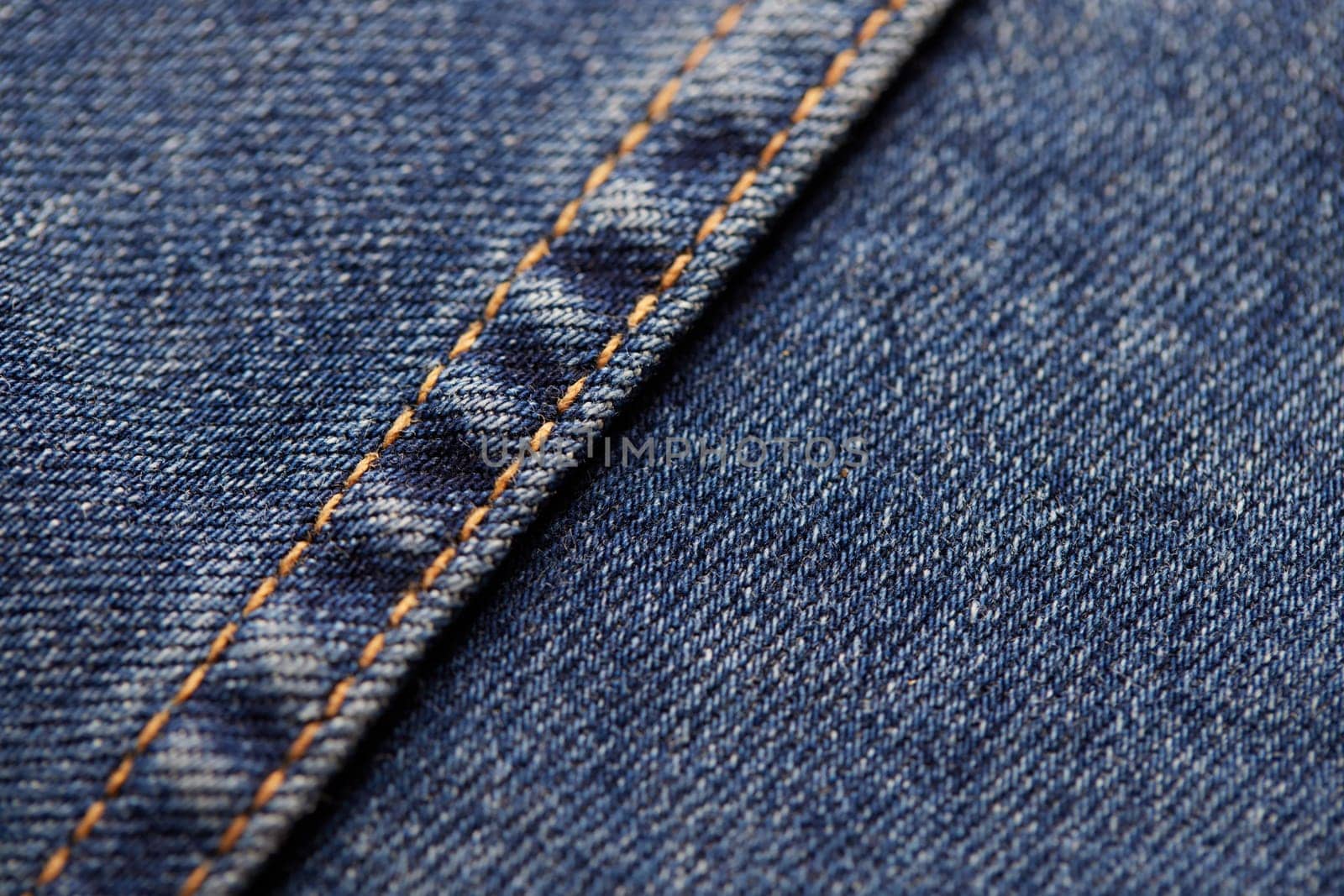 Seams on jeans close-up. Stitching on denim. Fabric texture. Blue jeans background and texture. Close up of blue jeans background. Denim texture in high-resolution.
