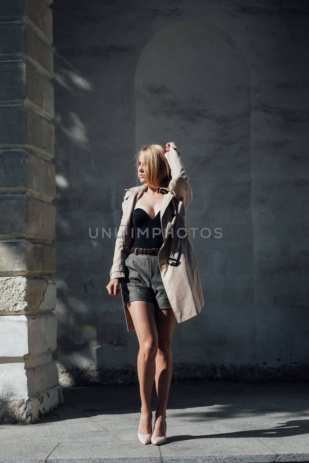 a fashionable blonde woman at the textured wall