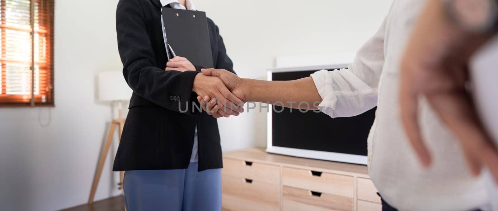 Couple asian handshake with a real estate agent after purchase a home by nateemee