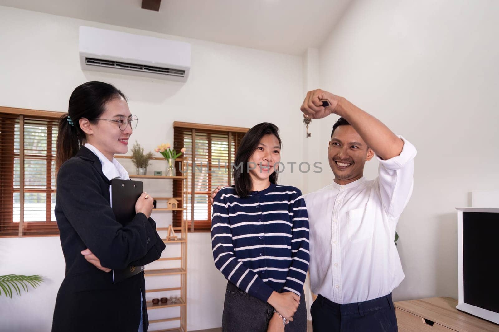 Happy couple asian buy their new home and receiv key from real estate agent.
