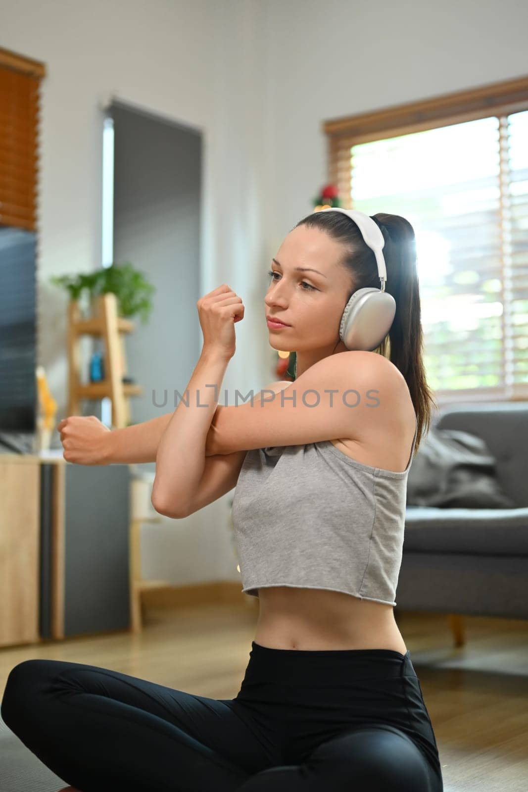 Young woman stretching her arms, warm up for morning workout. Healthy lifestyle concept.