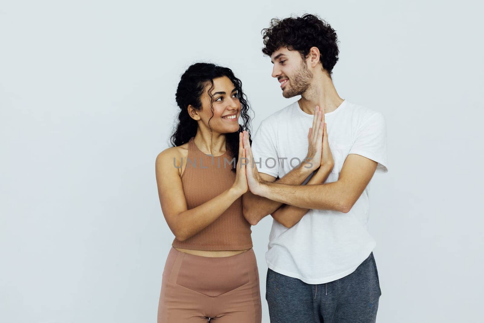 woman and a man put their hands together paired yoga
