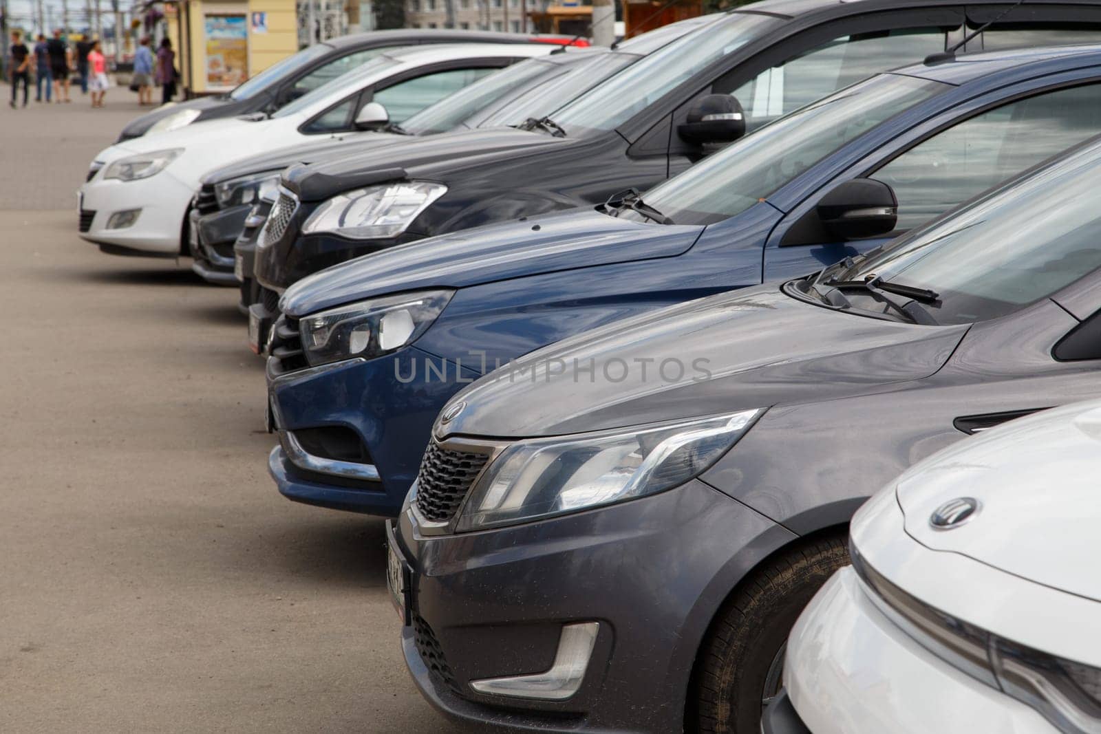 Tula, Russia - August 13, 2021: Row of cars on summer day parking - close-up view on front parts from side