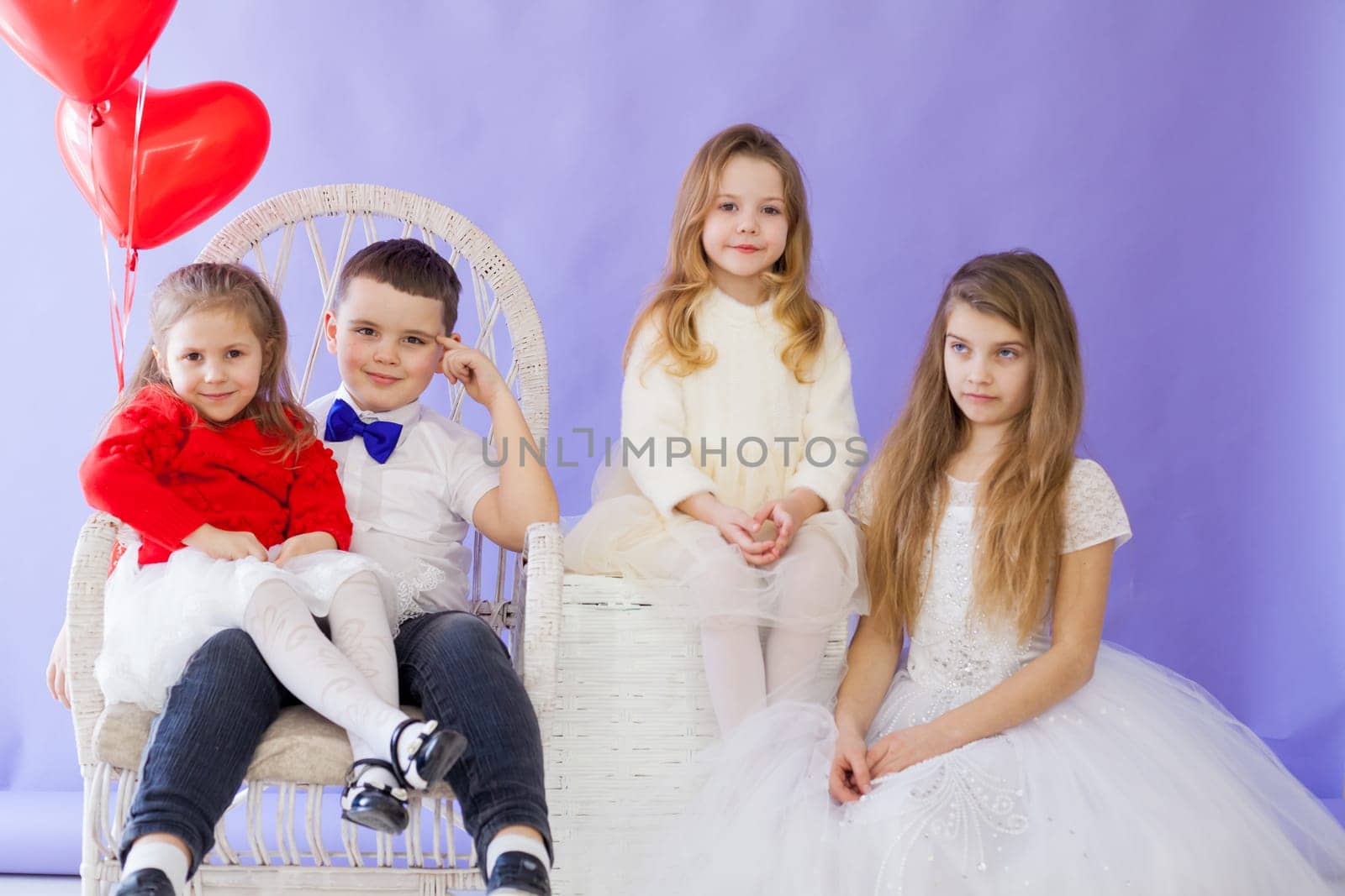 Children beautifully dressed waiting for a holiday with red Valentine's Day balls