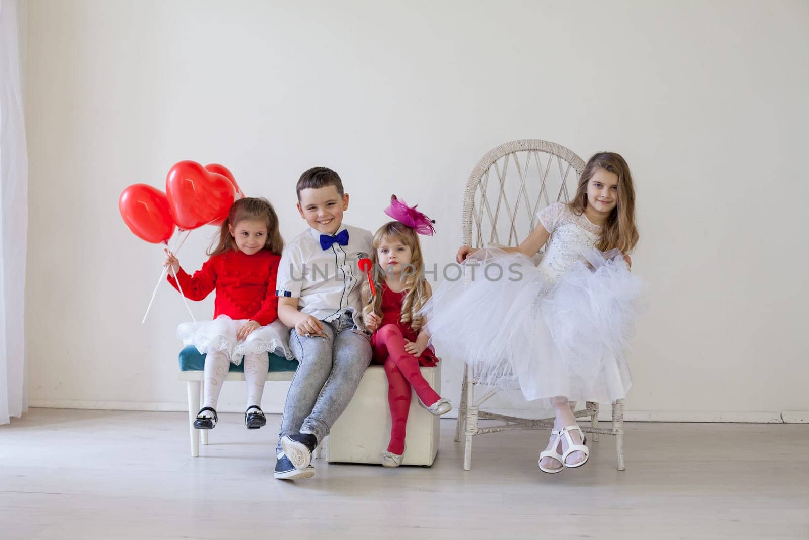 a beautiful children with red balls sitting on chairs