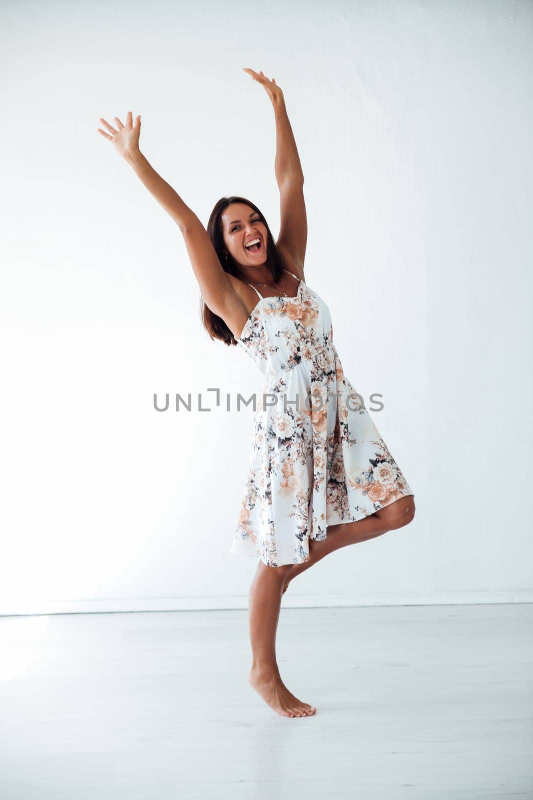 a woman smiling happy laughs contented standing on a white background with her hands up by Simakov