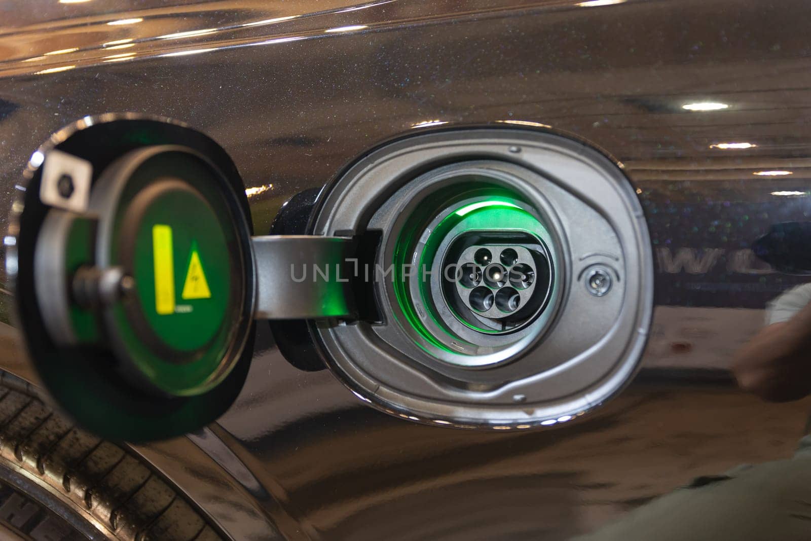 A Bright Green Light Shining on a Close-Up Metal Object: The Future of Electric Cars by Studia72