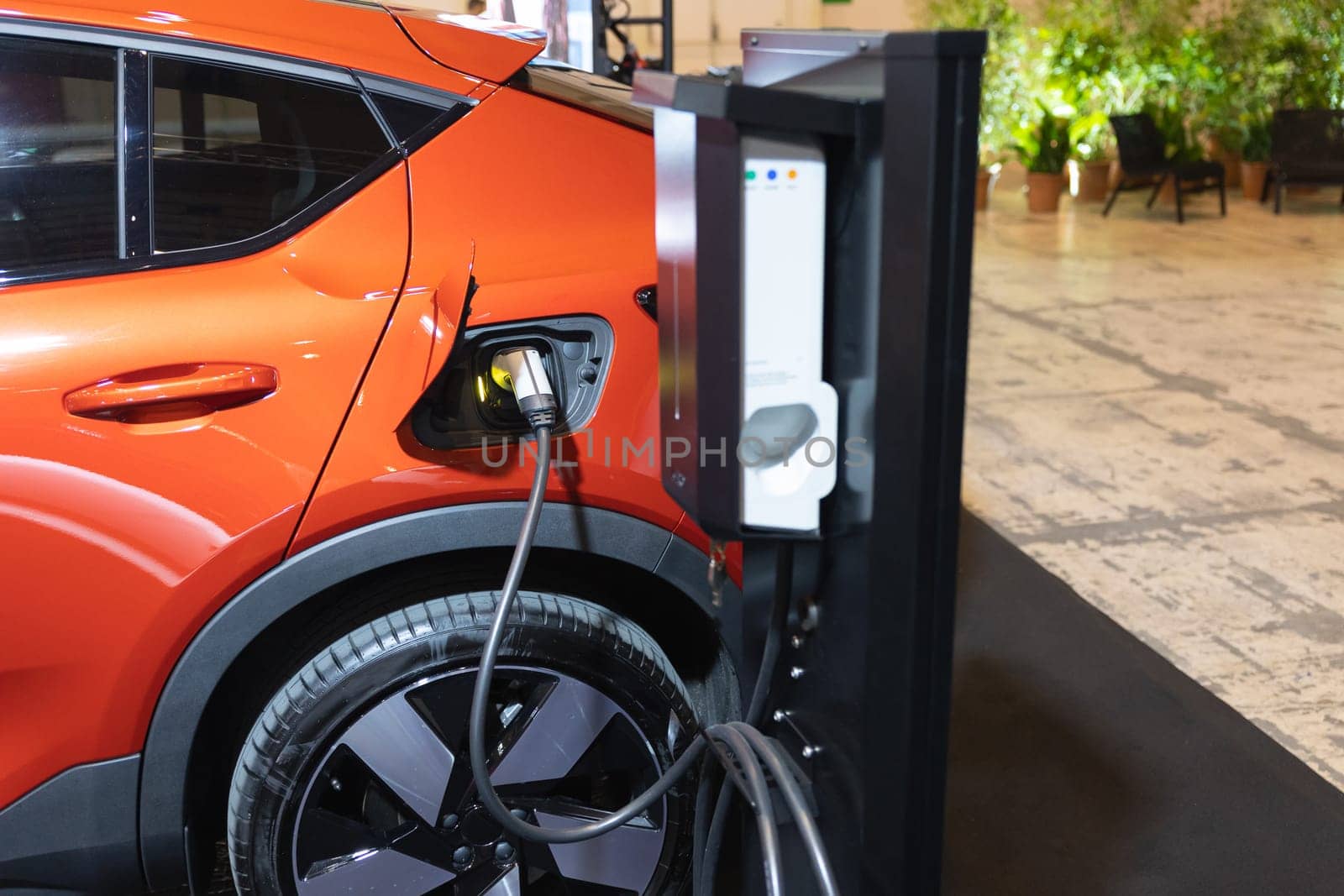 A Green Future: An Electric Car Plugged into a Charging Station by Studia72