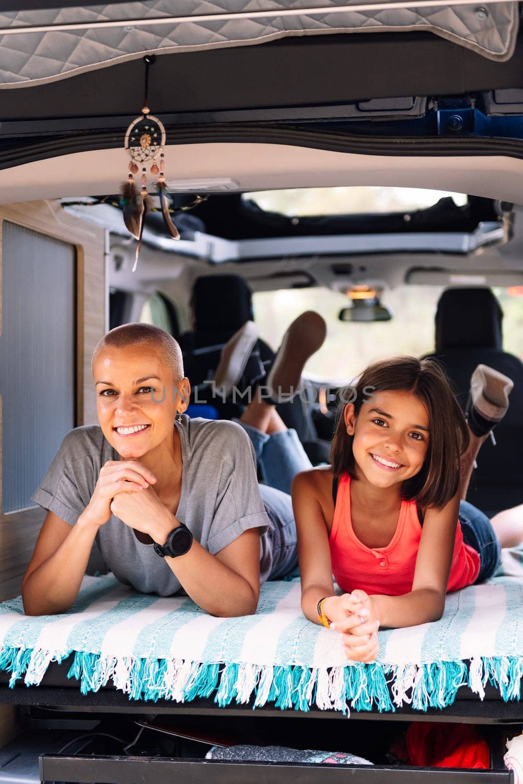 mother and daughter relaxing in their camper van by raulmelldo