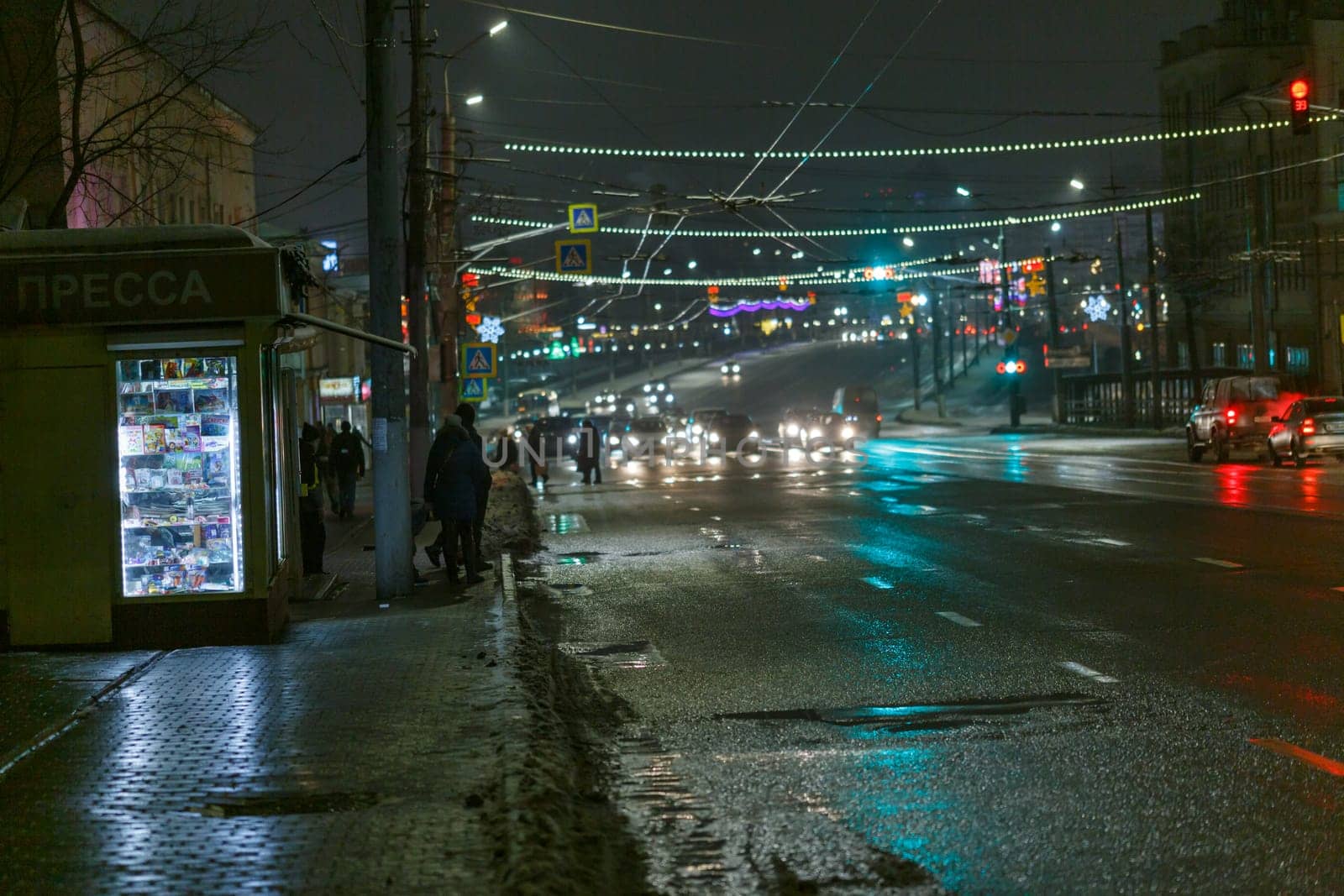 passengers at bus station near newspaper kiosk at winter night in Tula, Russia at December 20, 2020