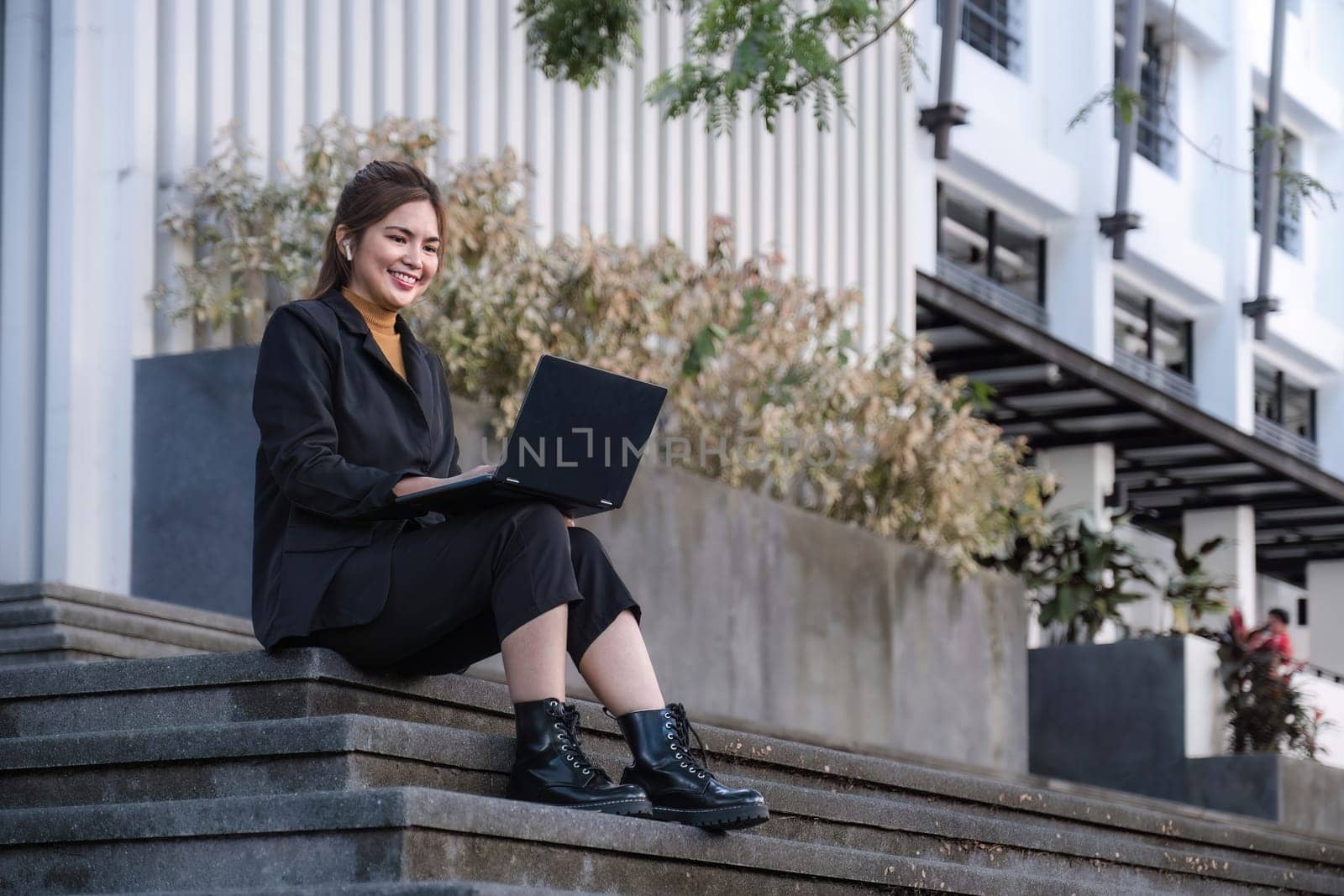 Asian businesswoman using a laptop computer and working outside the office.