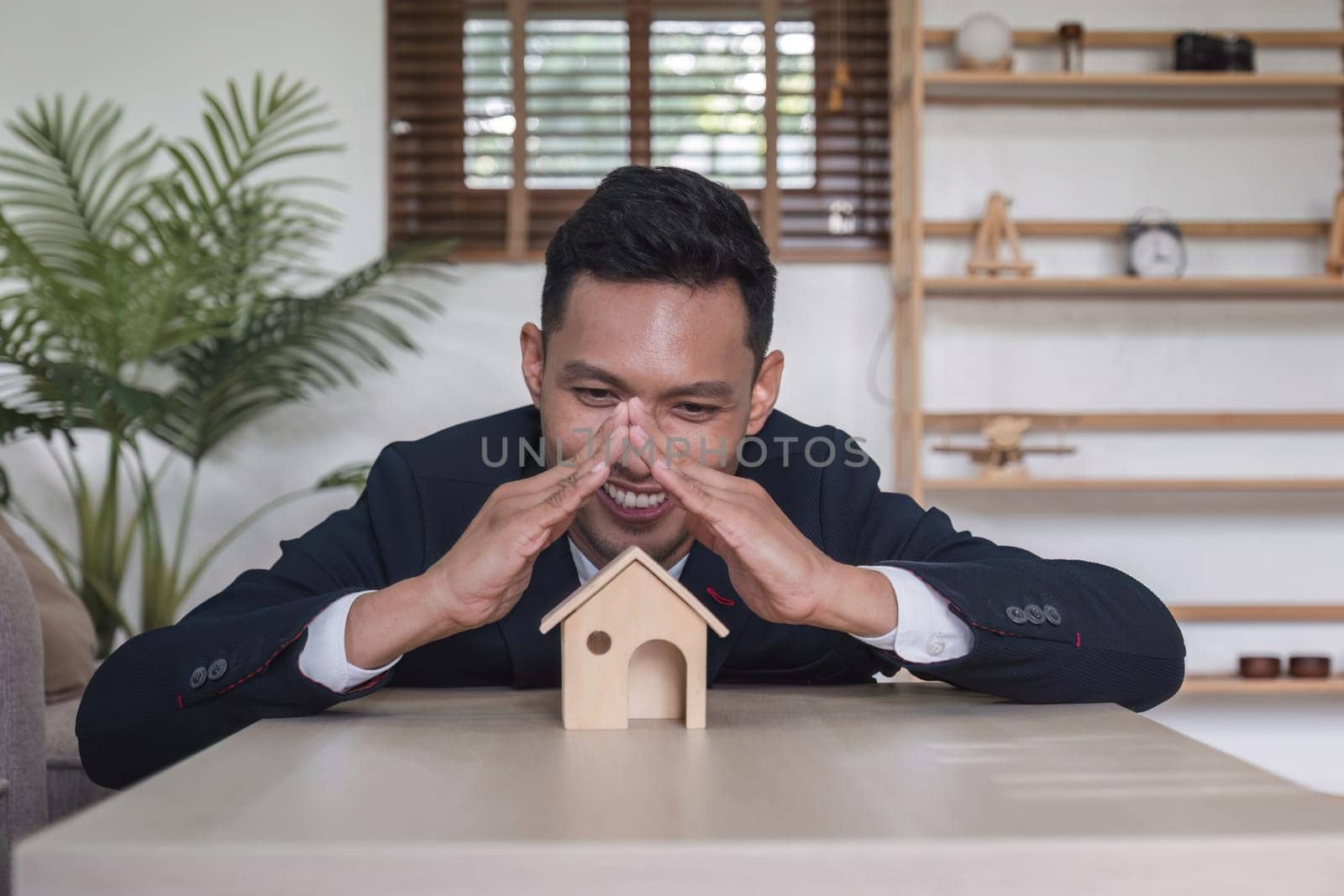 Real estate concept, businessman holds house icon. House in hand. Property insurance and security concept. and the symbol of the house by wichayada