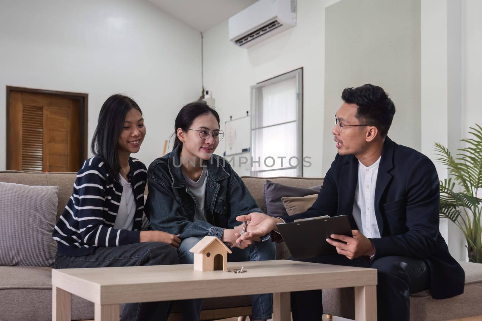 Real estate agents present and advise clients on the decision to sign a home purchase agreement form. Offering mortgage loans and home insurance.