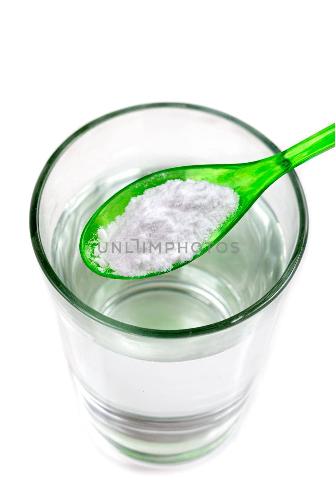 Spoon of baking soda over glass of water, isolated on white