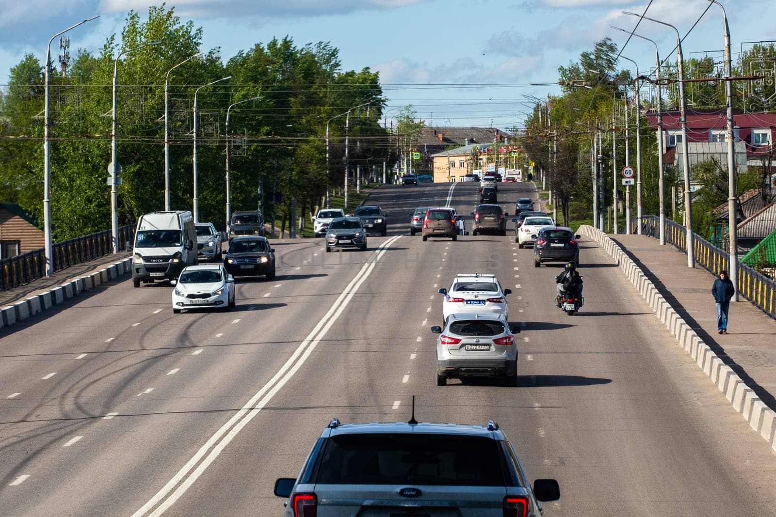 cars driving along bridge at sunny summer day in Tula, Russia - May 19, 2020