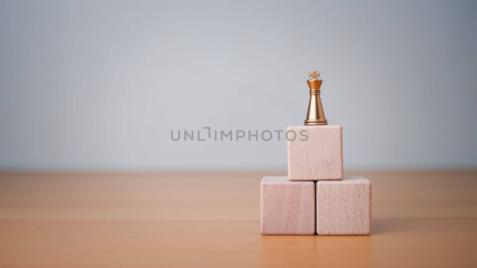 King placed on the topmost layer of wood. It represents the concept of competition and strategic adjustments for competitors in the business. by Unimages2527