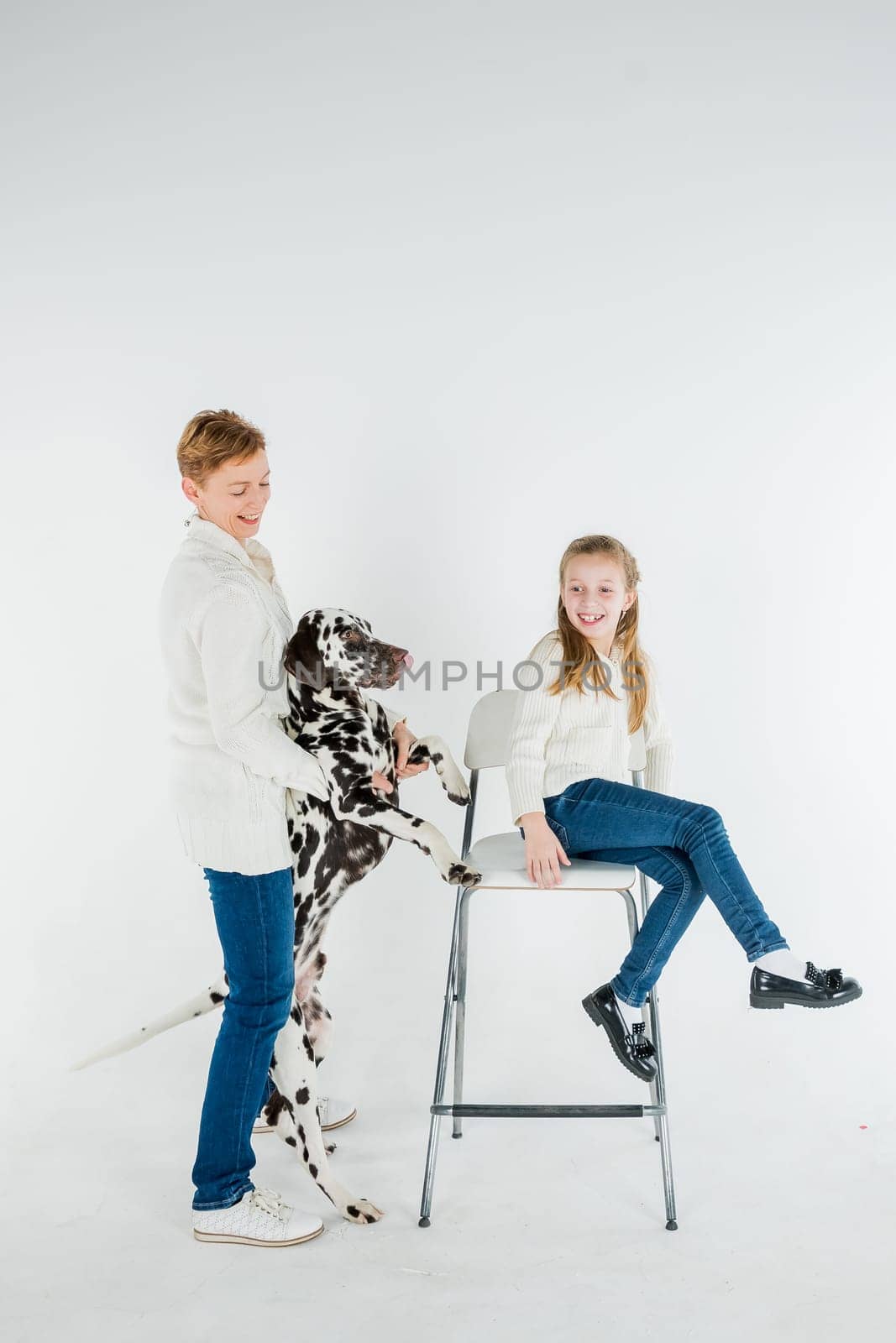 woman and toddler girl play with dog puppy dalmatian.pet and child ,generation therapy ,canisterapie,emotion, mental health. people hugging and kissing a dog, playing with puppy on a white background by YuliaYaspe1979