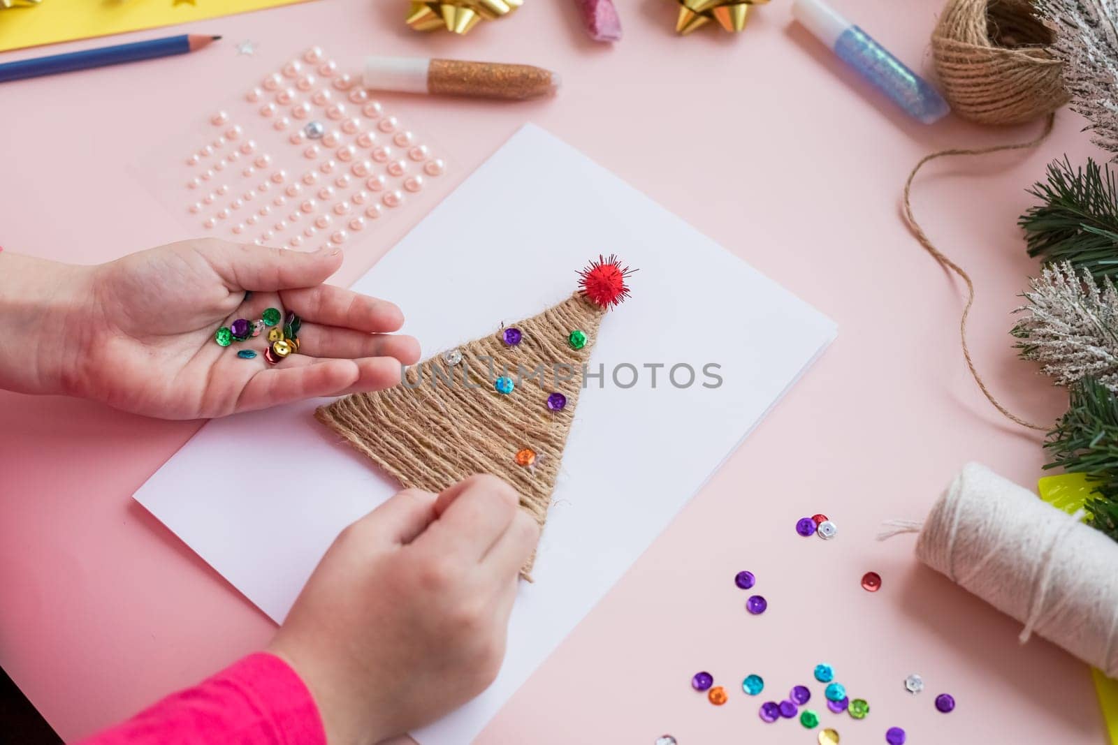 the child makes a New Year card for the winter holidays. DIY crafts and crafts for Christmas do-it-yourself concept