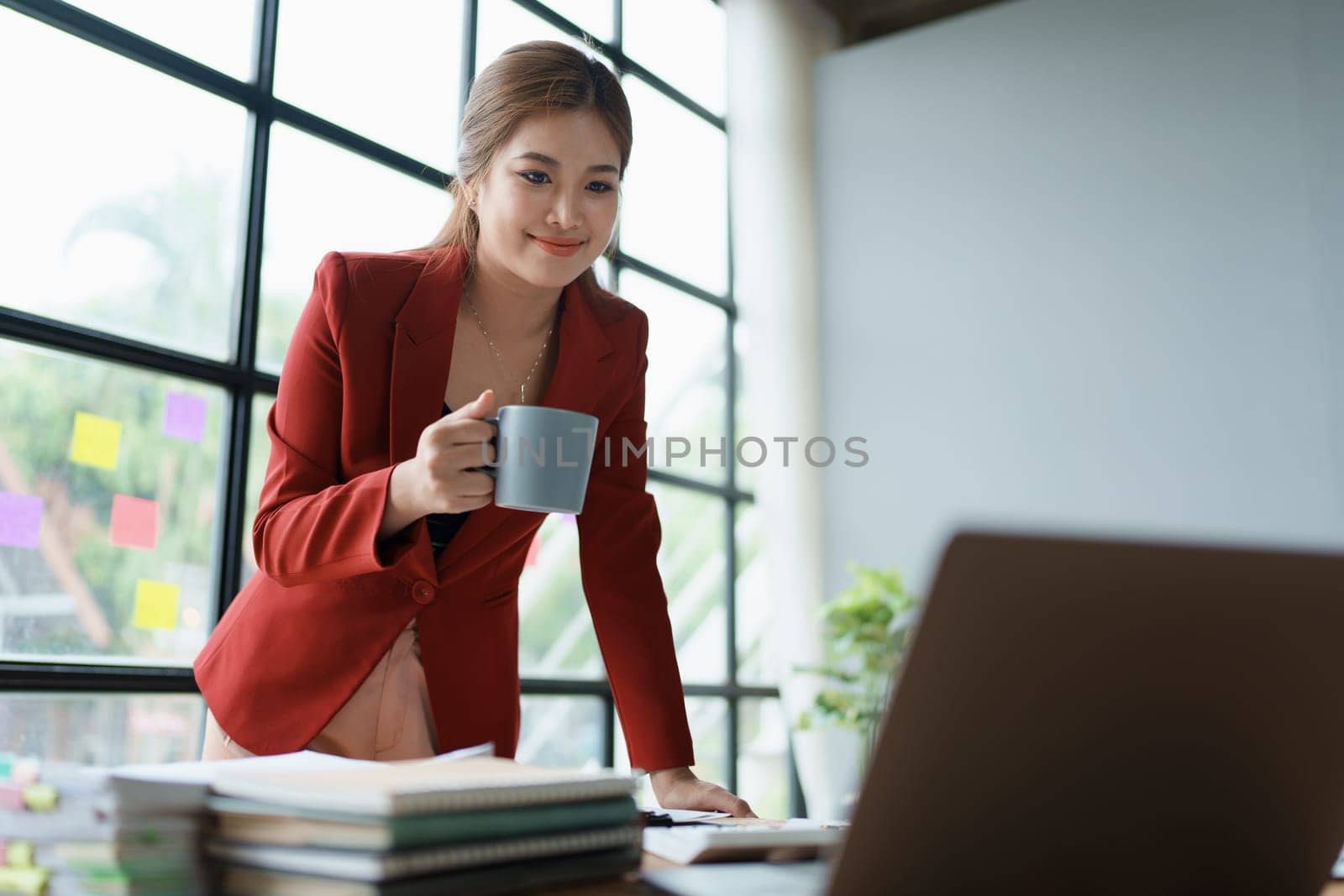 Businesswoman enjoys relaxing with a cup of coffee after a long day. by Manastrong