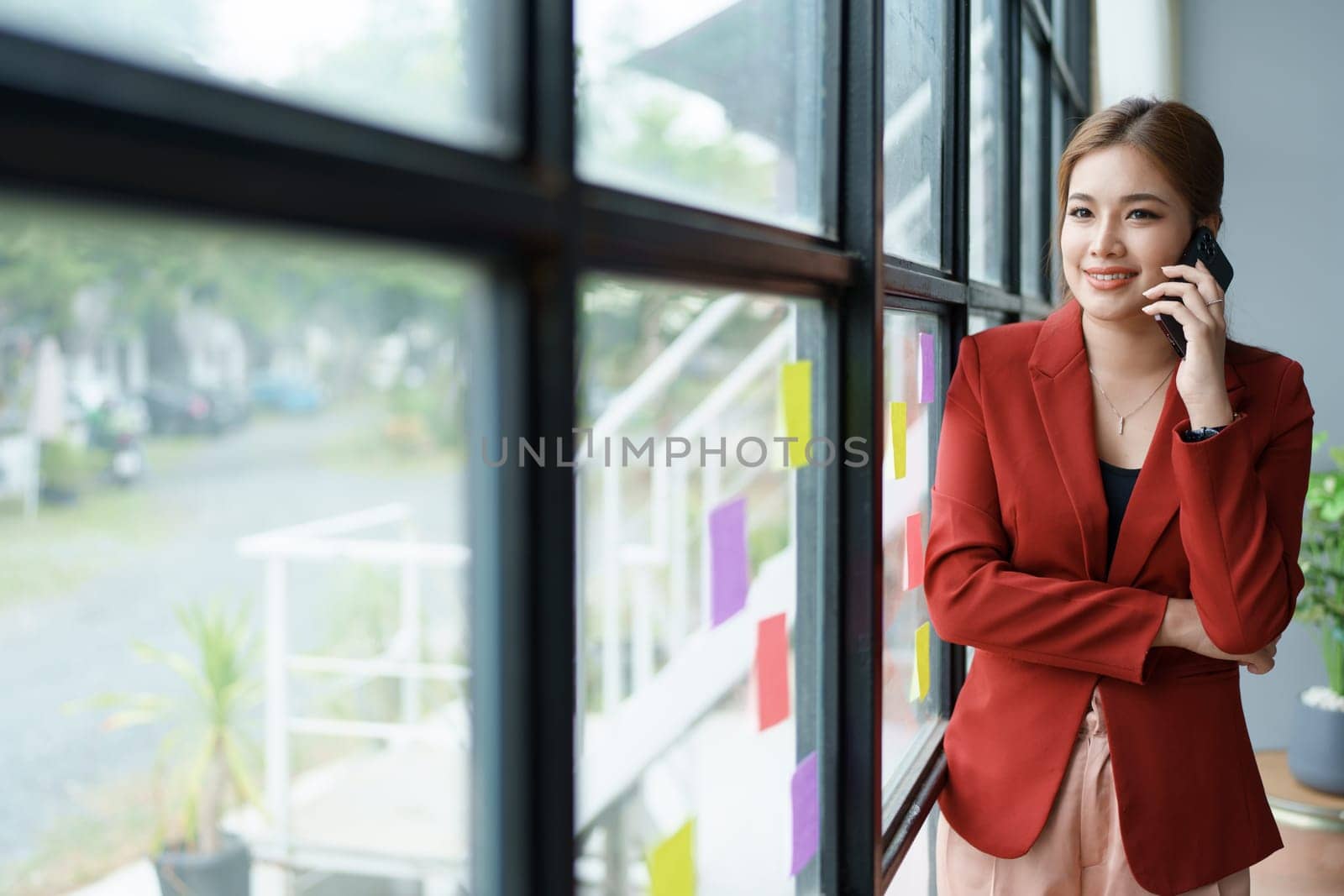 The businesswoman using smartphone mobile discuss the project, and use note paper to jot down important points. by Manastrong