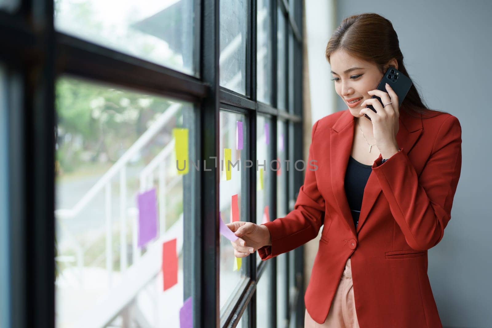 The businesswoman using smartphone mobile discuss the project, and use note paper to jot down important points
