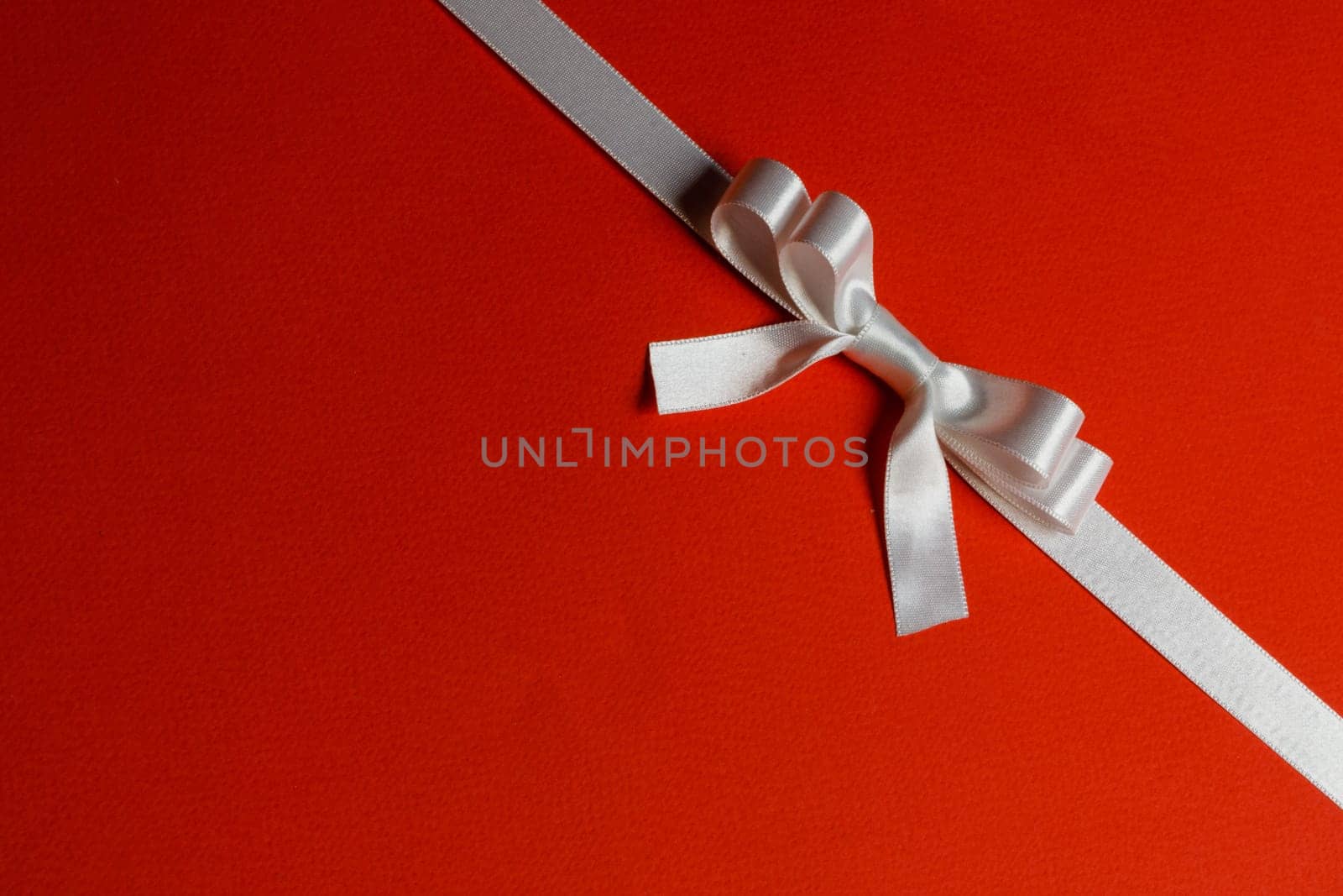 White gift bow on red background holiday gift concept