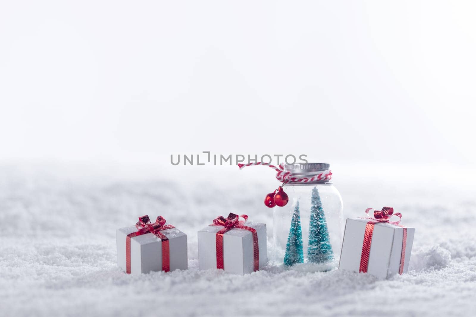 Christmas decor in snow gifts with red bows, white copy space for text