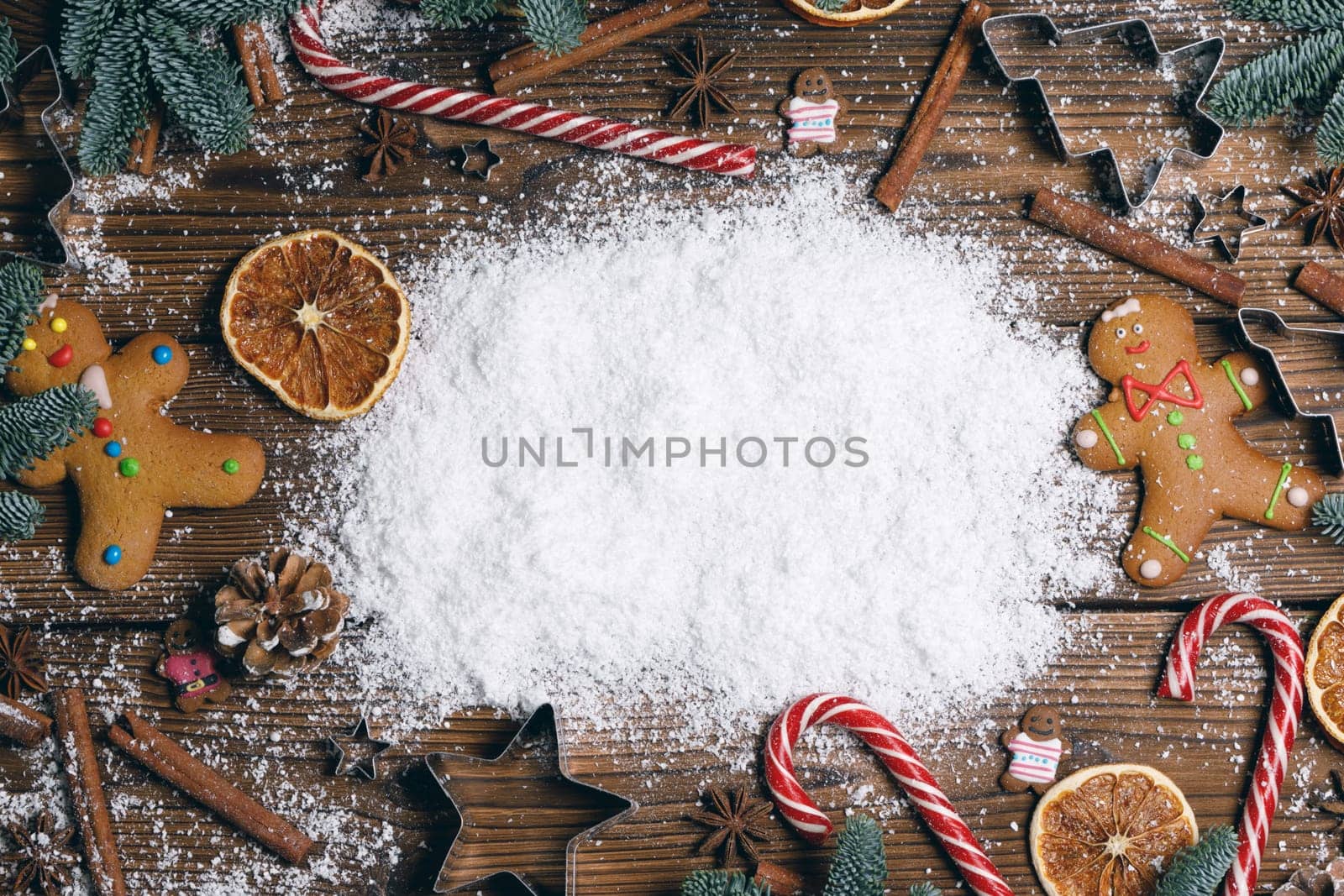 Christmas food frame. Gingerbread cookies, spices and decorations on wooden background with white copy space on snow