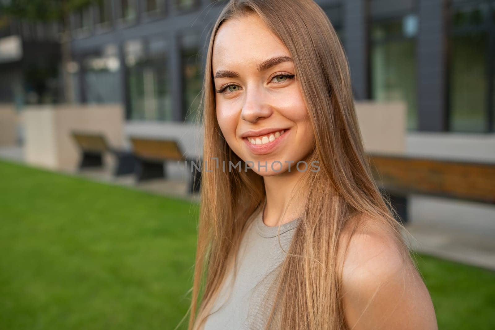 Portrait of young long hair with perfect smile standing in the street.