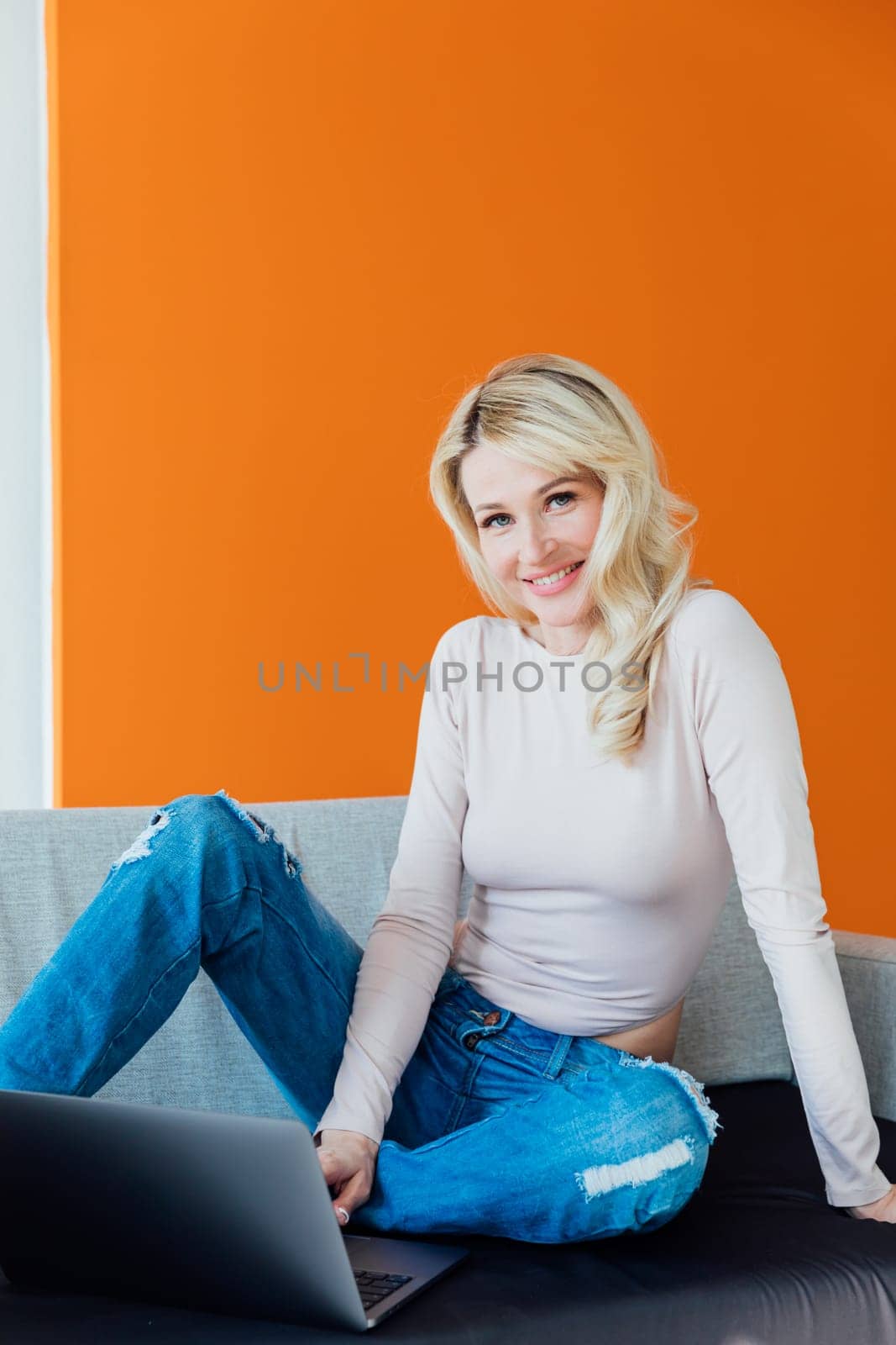 a beautiful blonde woman in a room with a laptop online communication internet remote work