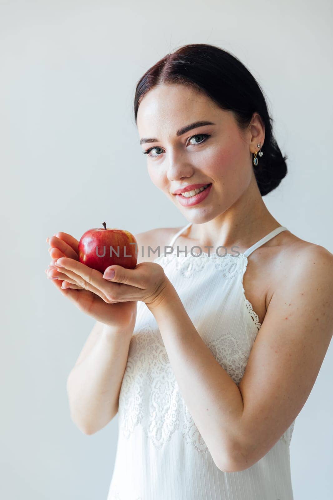 a beautiful woman holding a red apple in her hands