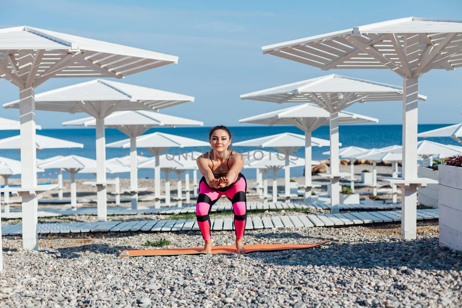 woman on the beach does exercises morning warm-up sports gymnastics exercises