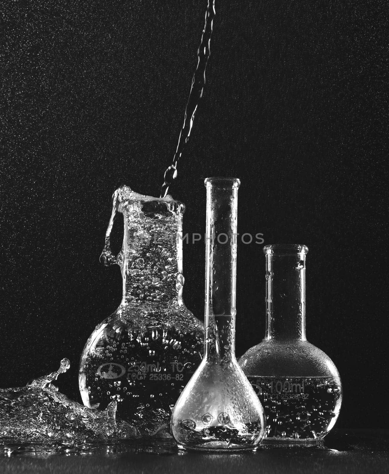 Transparent flasks with liquid on a black background