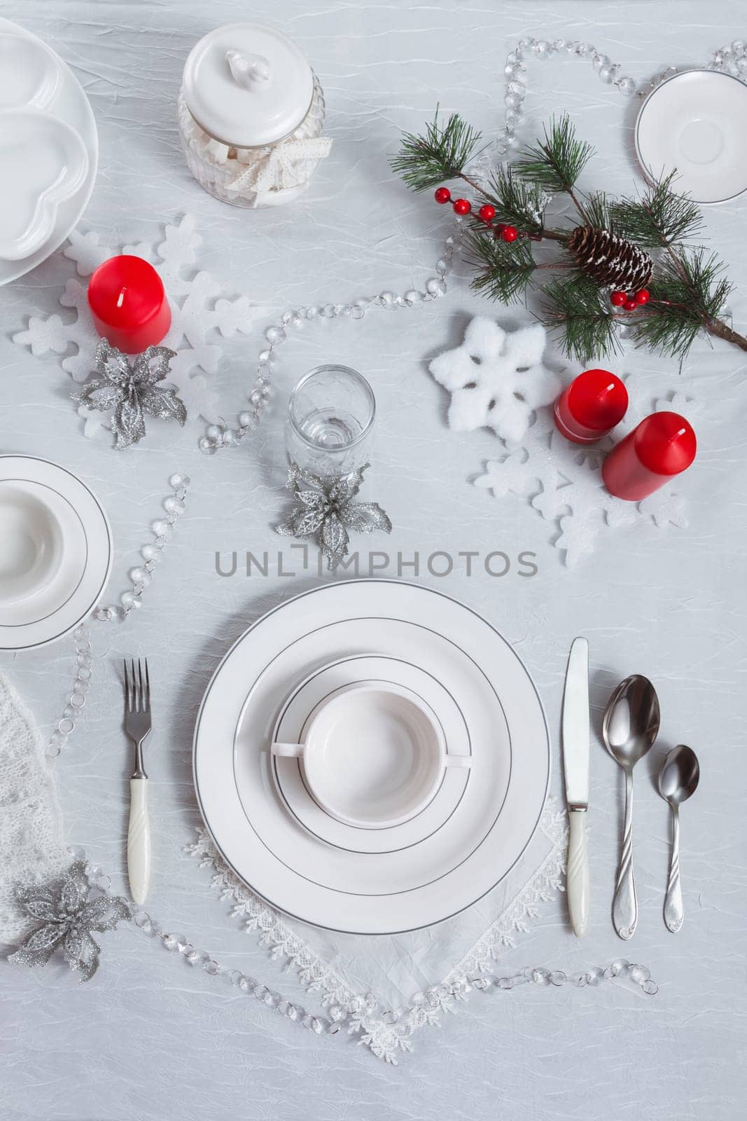 Table setting for New Year and Christmas for one person with a white tablecloth and a soup plate. Top view, festive table decoration by ElenaNEL