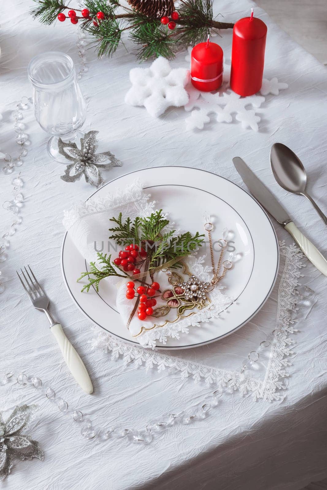 Festive table setting with a white tablecloth and plates. Decoration for the New Year and Christmas