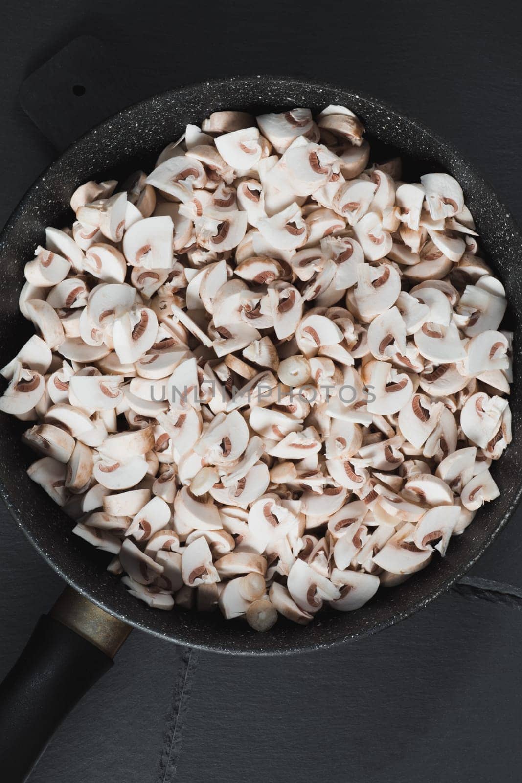 Sliced mushrooms in a frying pan are ready for frying