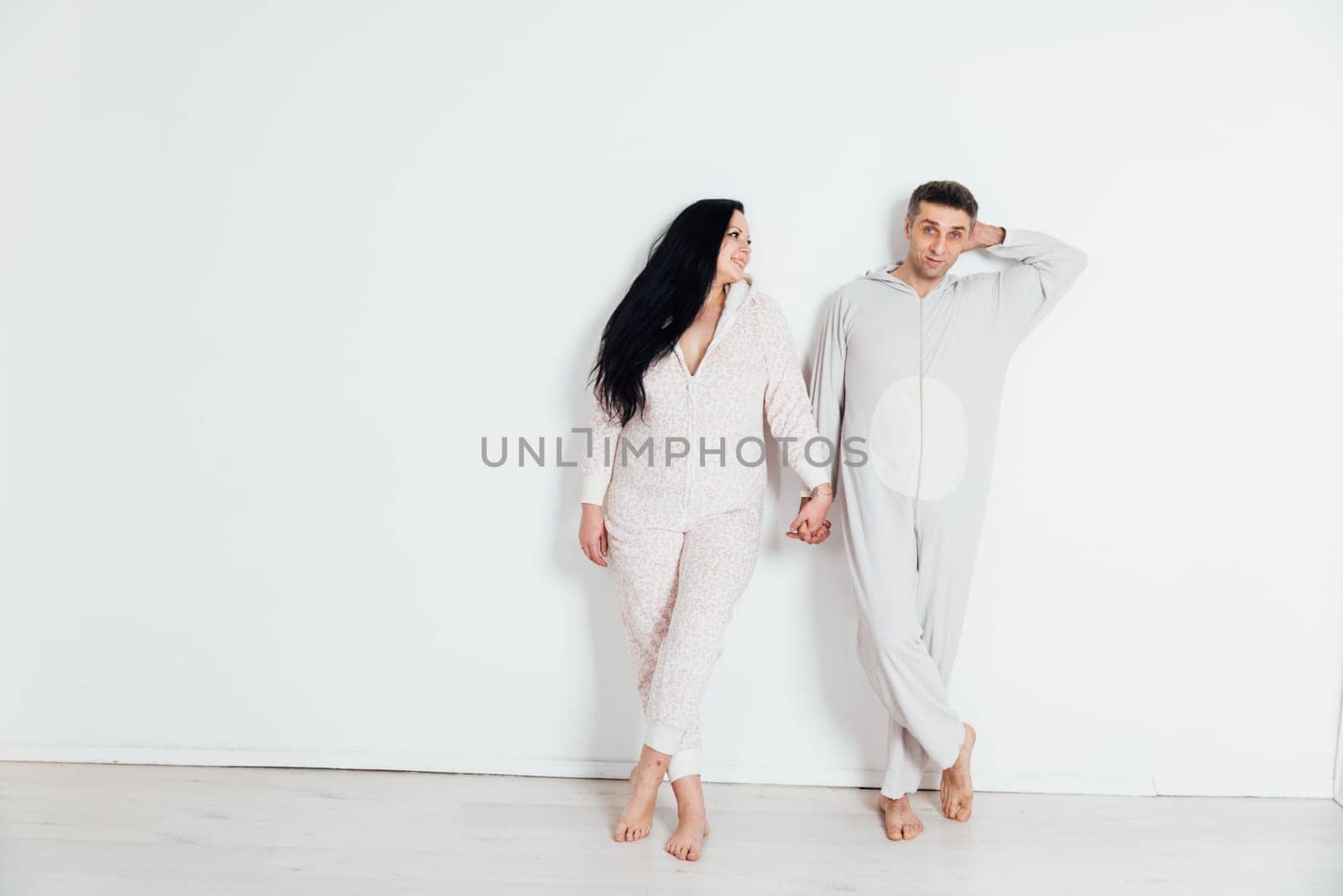 woman and man in pajamas in a bright room on a white background husband and wife lovers