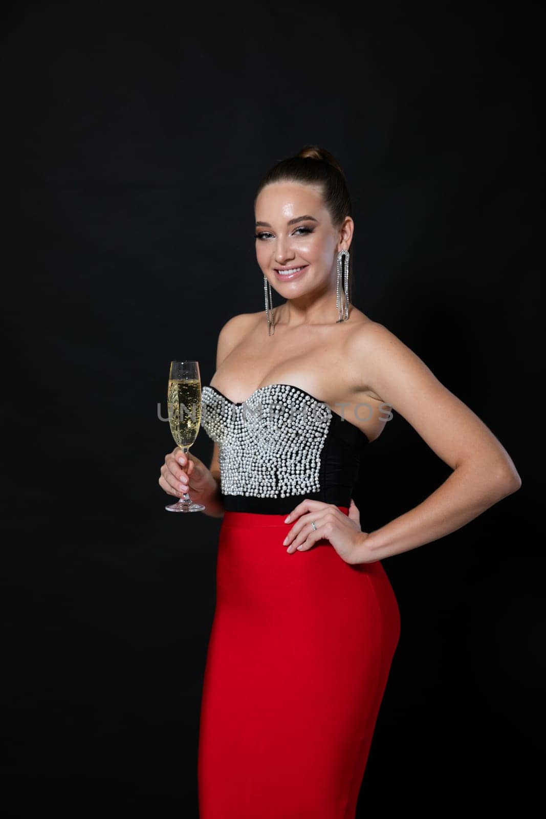 woman in beautiful clothes stands with a glass of champagne holiday